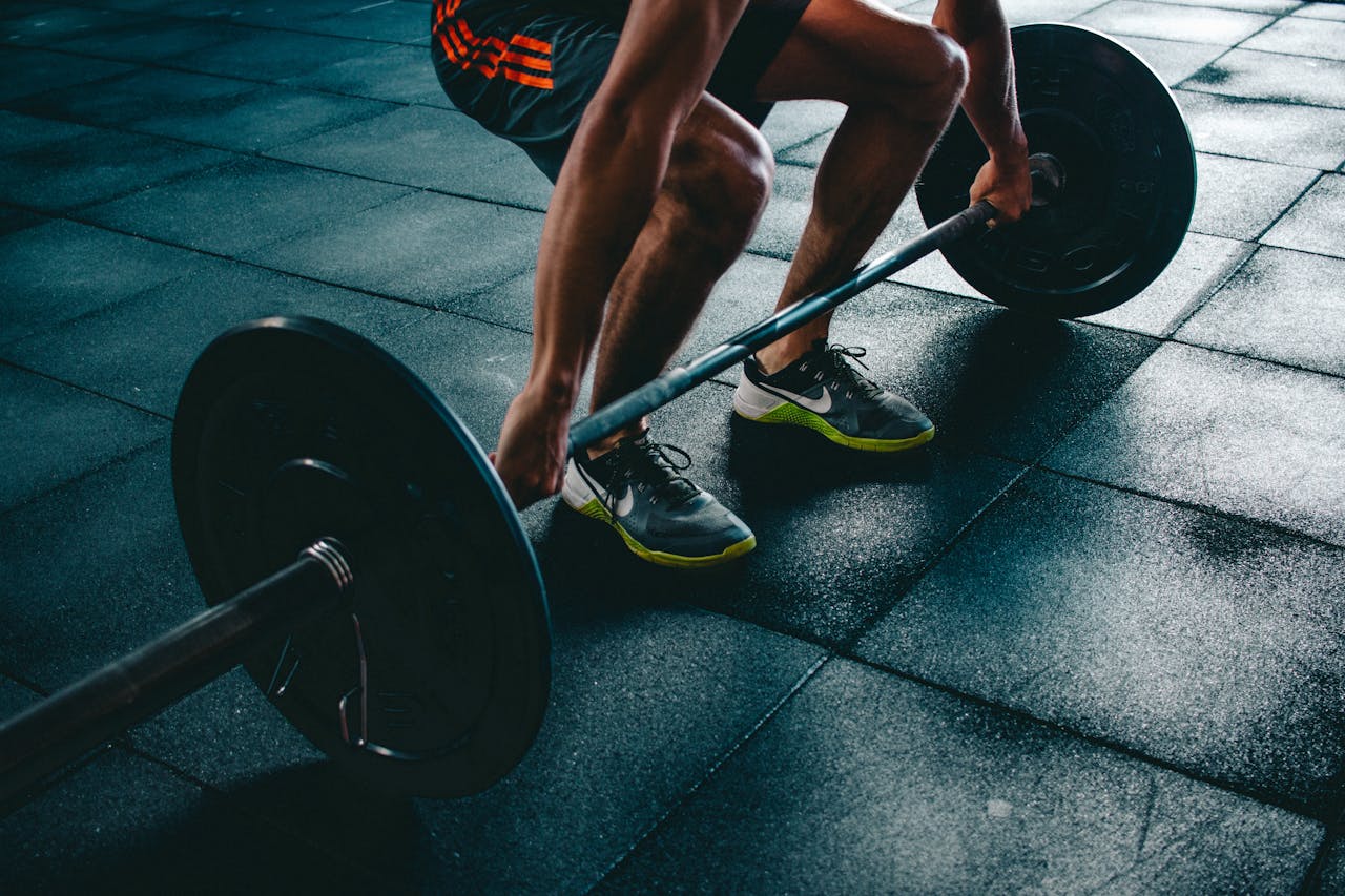 Home Man performing a deadlift exercise in a gym, demonstrating strength and fitness.